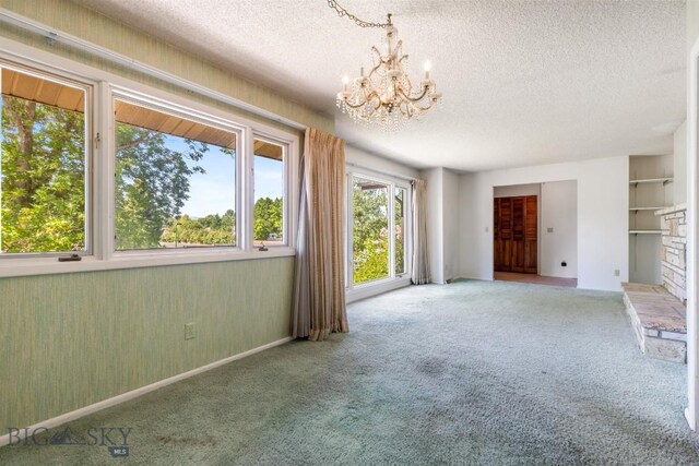 117 Henderson St, Bozeman, MT 59715 - unfurnished living room with a chandelier, a textured ceiling, and carpet flooring
