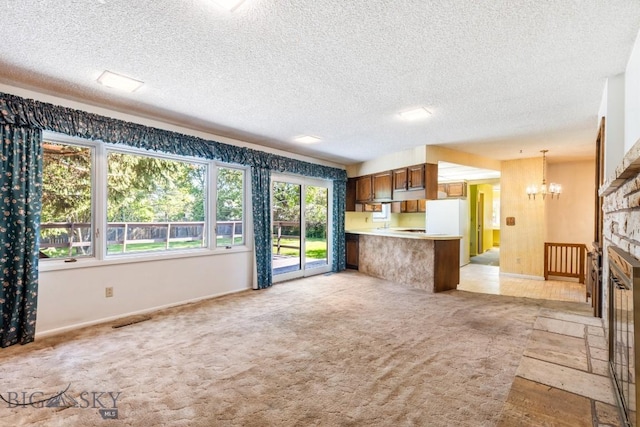 117 Henderson St, Bozeman, MT 59715 - kitchen featuring a chandelier, brown cabinets, open floor plan, a peninsula, and light countertops