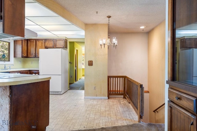 117 Henderson St, Bozeman, MT 59715 - kitchen with freestanding refrigerator, a chandelier, brick patterned flooring, hanging light fixtures, and light countertops