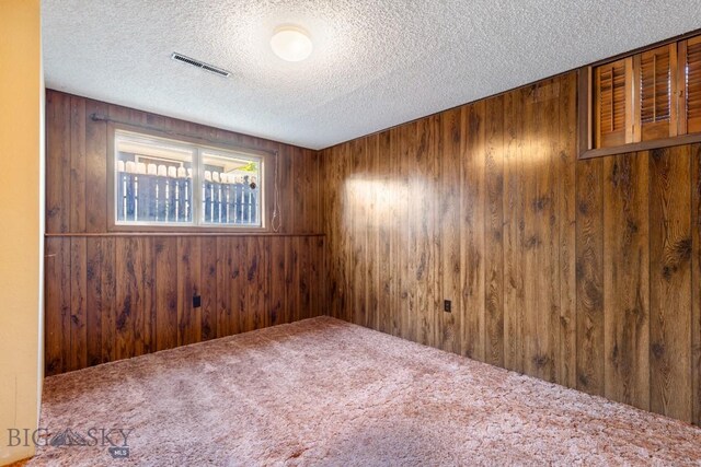 117 Henderson St, Bozeman, MT 59715 - spare room featuring a textured ceiling, wood walls, and carpet