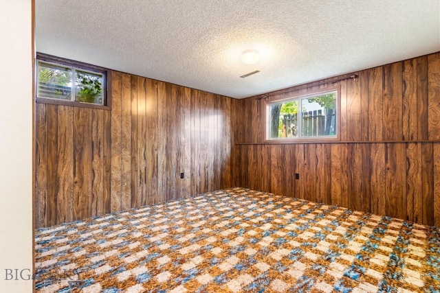 117 Henderson St, Bozeman, MT 59715 - carpeted empty room featuring wooden walls and a textured ceiling