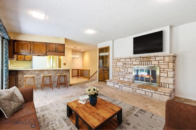 117 Henderson St, Bozeman, MT 59715 - carpeted living room with a textured ceiling, a chandelier, and a fireplace