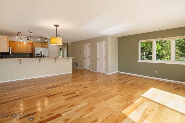 104 S Yellowstone Ave Unit 1, Bozeman, MT 59718 - unfurnished living room featuring light wood-style floors and baseboards