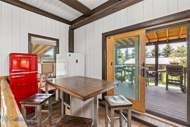 3573 Spain Bridge Rd, Belgrade, MT 59714 - dining area featuring beamed ceiling, wood finished floors, and wood walls