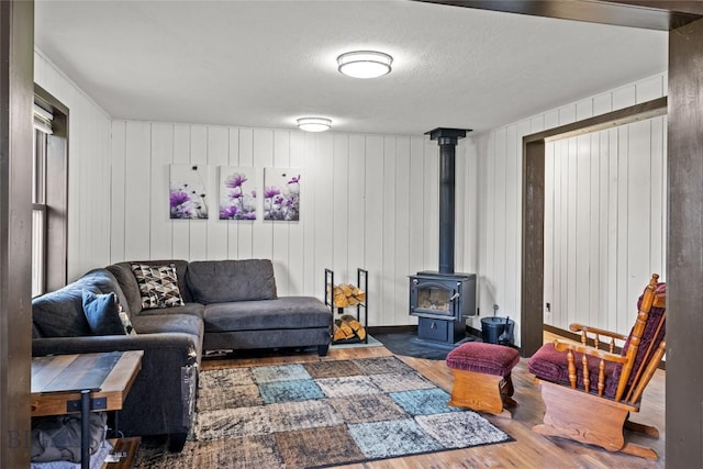 3573 Spain Bridge Rd, Belgrade, MT 59714 - living area with wood finished floors, a wood stove, and a textured ceiling