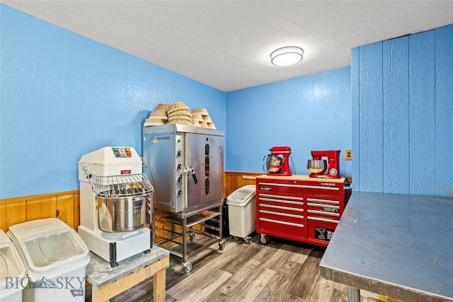3573 Spain Bridge Rd, Belgrade, MT 59714 - bedroom with wood finished floors, a wainscoted wall, wood walls, a textured wall, and a textured ceiling