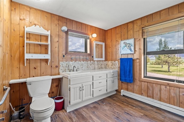 3573 Spain Bridge Rd, Belgrade, MT 59714 - bathroom with baseboard heating, vanity, wood walls, and wood finished floors