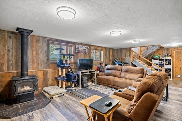 3573 Spain Bridge Rd, Belgrade, MT 59714 - living room with wood walls, stairs, a wood stove, wood finished floors, and a textured ceiling