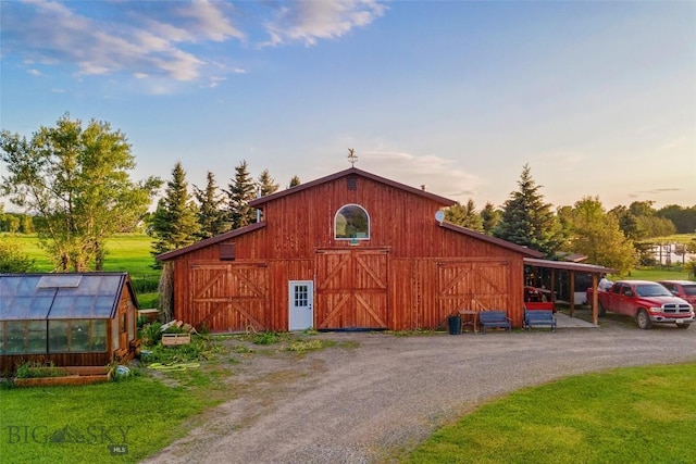 3573 Spain Bridge Rd, Belgrade, MT 59714 - outdoor structure at dusk featuring a barn, an exterior structure, a yard, and dirt driveway