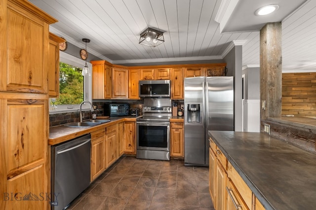 24151 Frontage Rd, Bozeman, MT 59718 - kitchen featuring appliances with stainless steel finishes, dark countertops, ornamental molding, hanging light fixtures, and brown cabinets