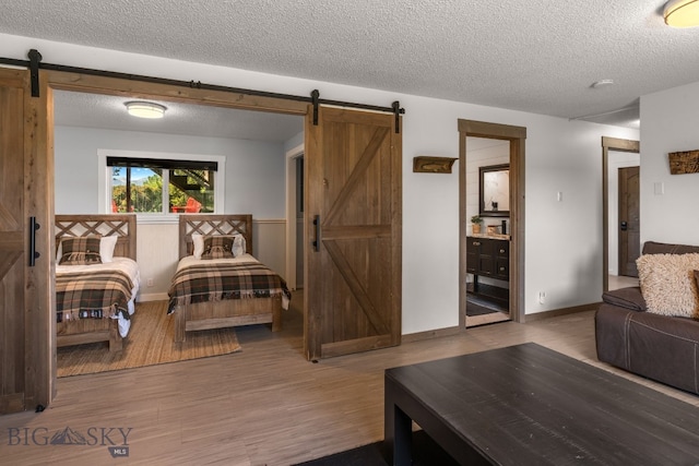 24151 Frontage Rd, Bozeman, MT 59718 - living room featuring a barn door, a textured ceiling, and wood finished floors