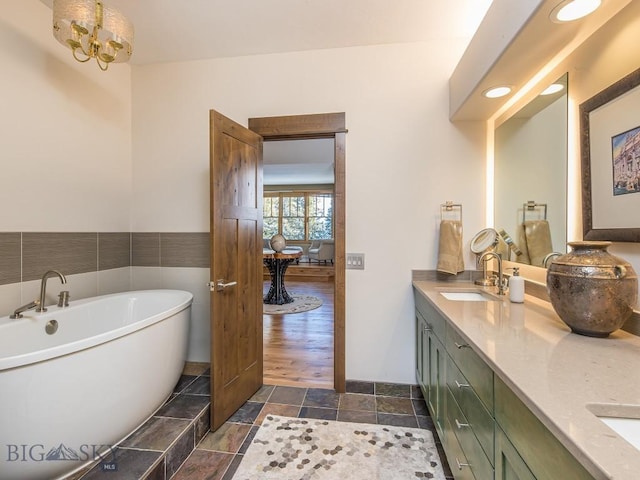 1255 Andesite Rd, Big Sky, MT 59716 - full bathroom with a freestanding bath, double vanity, stone tile floors, and a chandelier