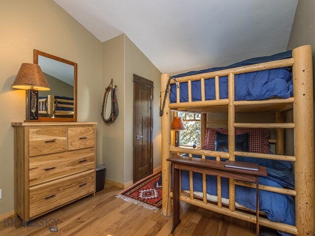 1255 Andesite Rd, Big Sky, MT 59716 - bedroom with vaulted ceiling and wood finished floors