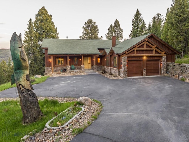 725 Sandhill Rd, Big Sky, MT 59716 - view of front facade with stone siding, a porch, and an attached garage