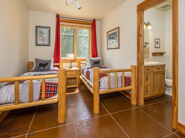 725 Sandhill Rd, Big Sky, MT 59716 - bedroom featuring connected bathroom and dark tile patterned floors