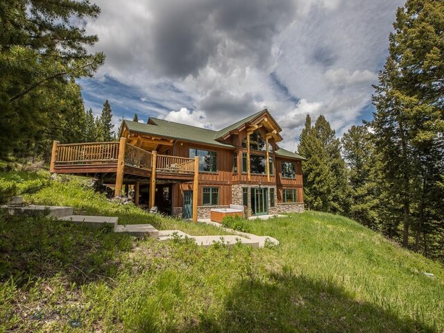725 Sandhill Rd, Big Sky, MT 59716 - back of property with board and batten siding, stone siding, and a wooden deck