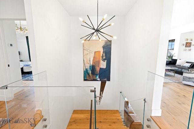 557 St Andrews, Bozeman, MT 59715 - hallway featuring a chandelier, wood finished floors, and an upstairs landing