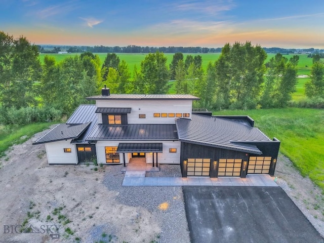 33 Leachman Ln, Bozeman, MT 59718 - rear view of property with a standing seam roof, a metal roof, asphalt driveway, a chimney, and an attached garage