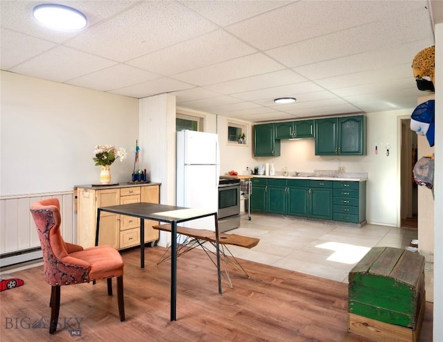 8373 Goldenstein Ln, Bozeman, MT 59715 - kitchen with green cabinetry, freestanding refrigerator, stainless steel stove, light wood-style flooring, and a drop ceiling