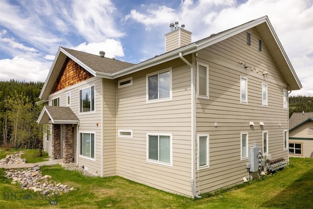 13 Moose Ridge Rd, Big Sky, MT 59716 - back of house featuring a chimney and a yard