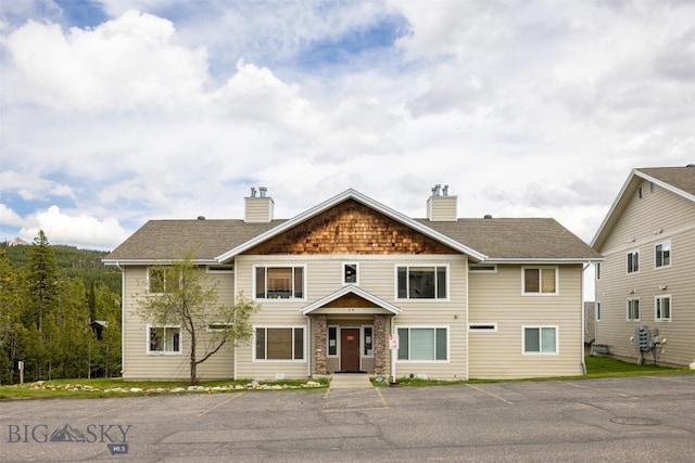 13 Moose Ridge Rd, Big Sky, MT 59716 - view of front facade with a chimney and uncovered parking