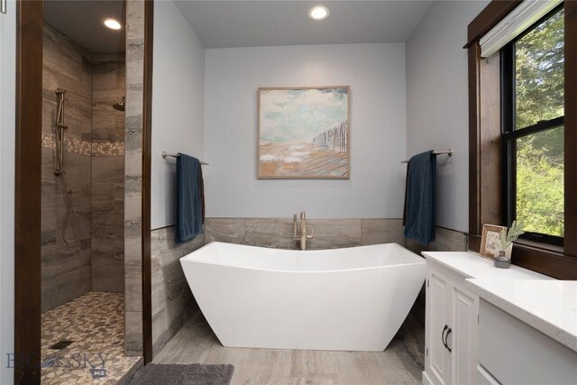 13011 Cottonwood Canyon Rd, Bozeman, MT 59718 - full bath featuring tile walls, a freestanding bath, plenty of natural light, a tile shower, and recessed lighting