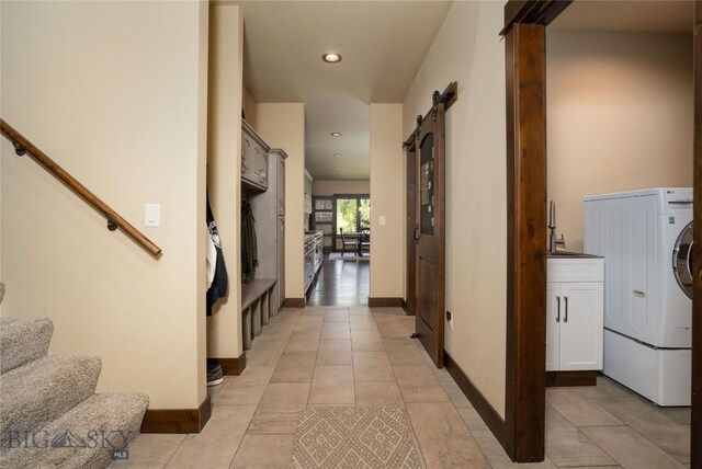 13011 Cottonwood Canyon Rd, Bozeman, MT 59718 - laundry area featuring washer / dryer, a barn door, light tile patterned floors, and recessed lighting