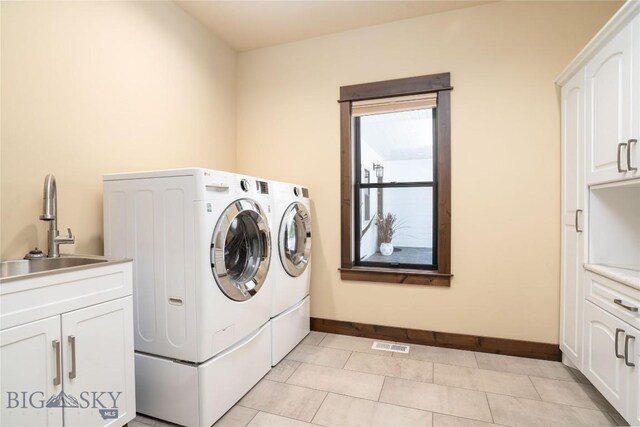 13011 Cottonwood Canyon Rd, Bozeman, MT 59718 - laundry room featuring separate washer and dryer, cabinet space, and light tile patterned floors