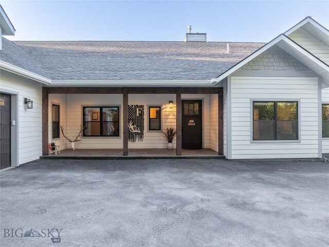 13011 Cottonwood Canyon Rd, Bozeman, MT 59718 - entrance to property featuring a shingled roof, a chimney, and a porch