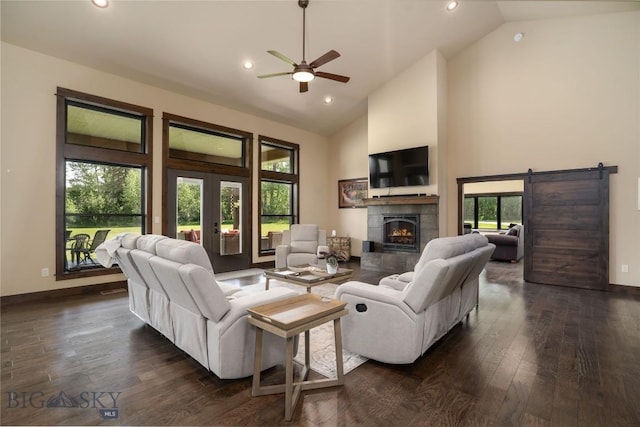13011 Cottonwood Canyon Rd, Bozeman, MT 59718 - living room featuring dark wood finished floors, high vaulted ceiling, ceiling fan, a tiled fireplace, and a barn door