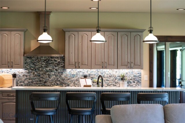 13011 Cottonwood Canyon Rd, Bozeman, MT 59718 - kitchen featuring backsplash, light countertops, a breakfast bar, gray cabinets, and recessed lighting