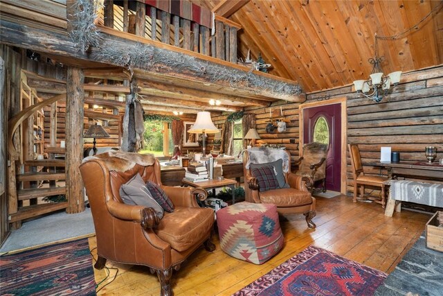 13011 Cottonwood Canyon Rd, Bozeman, MT 59718 - living room featuring log walls, high vaulted ceiling, hardwood / wood-style flooring, a chandelier, and a wooden ceiling with exposed beams