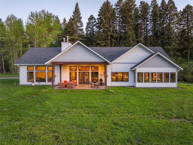 13011 Cottonwood Canyon Rd, Bozeman, MT 59718 - rear view of house with a chimney, outdoor lounge area, a yard, a patio, and a shingled roof