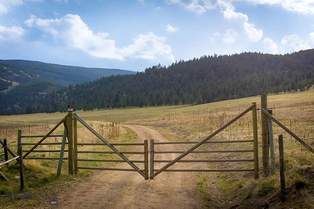 8337 Lamar Trl, Lolo, MT 59847 - gate featuring a wooded view, a view of rural / pastoral area, and a mountain view