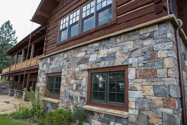 8337 Lamar Trl, Lolo, MT 59847 - view of side of property featuring stone siding and a patio area