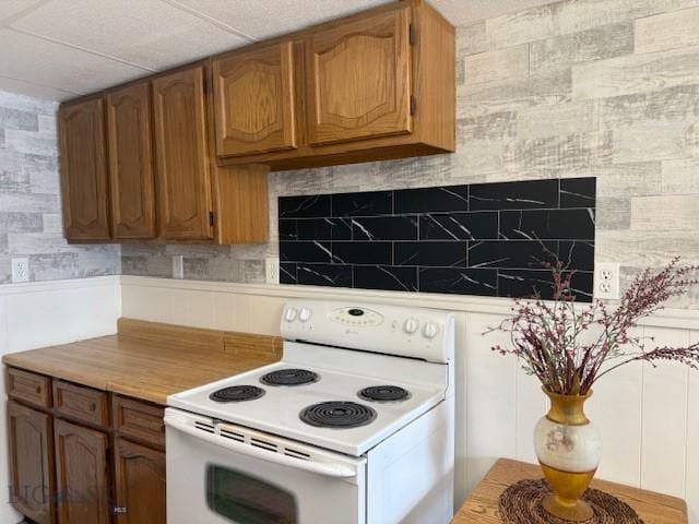 308 E 4th St, Anaconda, MT 59711 - kitchen featuring white range with electric cooktop, brown cabinetry, and tile counters