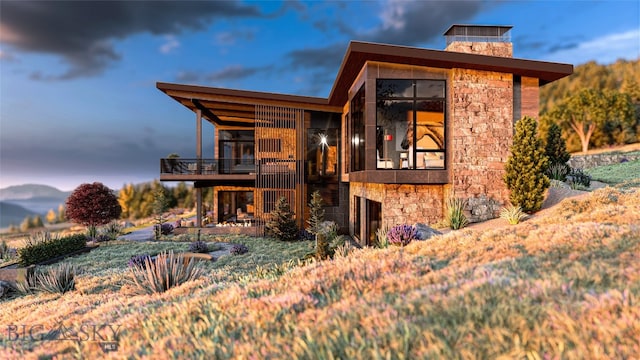 FourBarRanches Corbly Gulch, Belgrade, MT 59714 - view of front facade featuring stone siding, a balcony, and a chimney