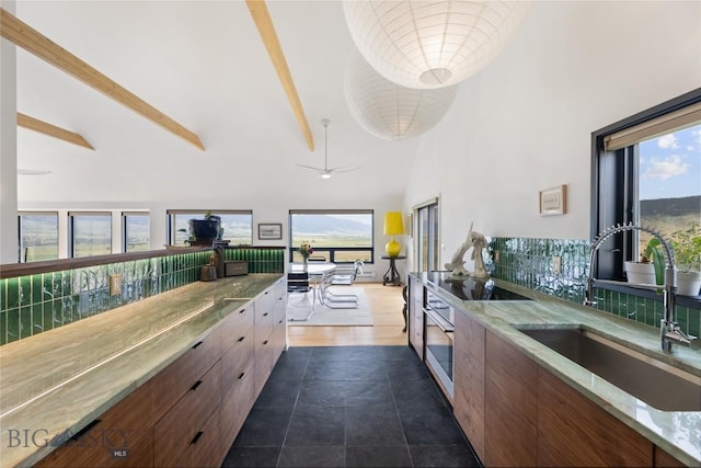145 Spring Creek Hills Rd, Livingston, MT 59047 - kitchen with high vaulted ceiling, modern cabinets, plenty of natural light, black electric cooktop, and beamed ceiling