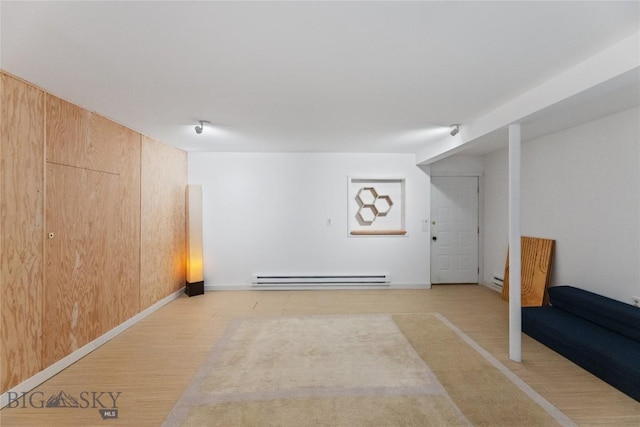 145 Spring Creek Hills Rd, Livingston, MT 59047 - finished below grade area featuring a baseboard radiator, wooden walls, and light wood-type flooring