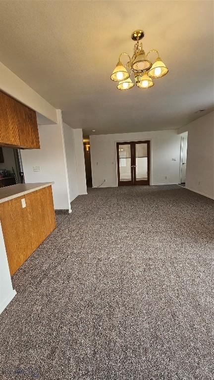 835 Forestglen Unit H, Bozeman, MT 59718 - unfurnished living room with a chandelier and speckle patterned floor