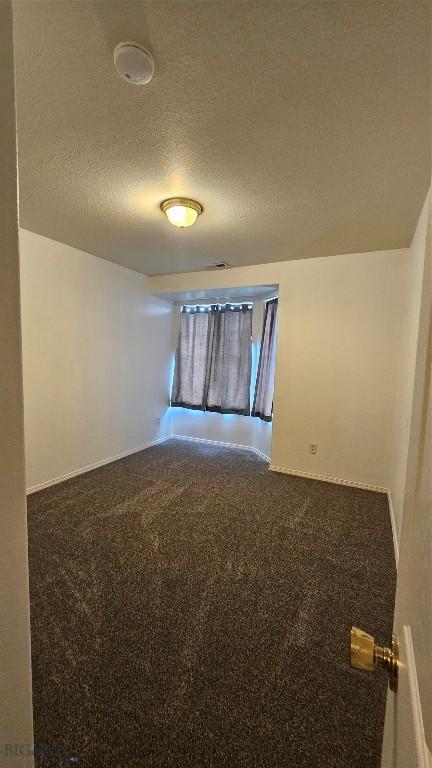 835 Forestglen Unit H, Bozeman, MT 59718 - unfurnished room with a textured ceiling, dark colored carpet, and a smoke detector