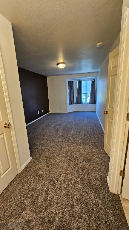 835 Forestglen Unit H, Bozeman, MT 59718 - spare room featuring carpet flooring, a textured ceiling, and a smoke detector