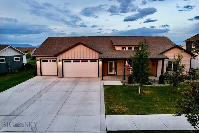 176 Travelers, Manhattan, MT 59741 - view of front of house featuring a garage, driveway, a front lawn, board and batten siding, and roof with shingles