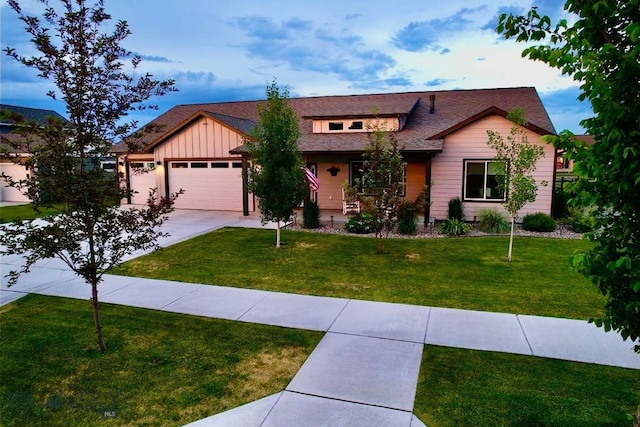 176 Travelers, Manhattan, MT 59741 - view of front facade featuring a front lawn, a garage, board and batten siding, and concrete driveway