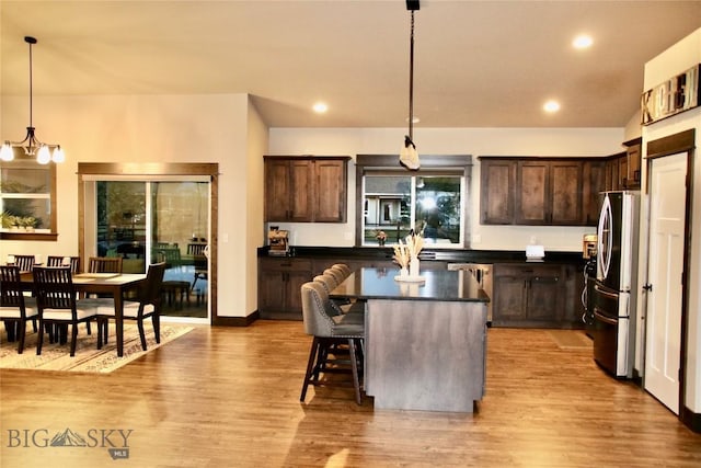 176 Travelers, Manhattan, MT 59741 - kitchen with stainless steel appliances, dark countertops, dark brown cabinets, a kitchen island, and light wood-style floors