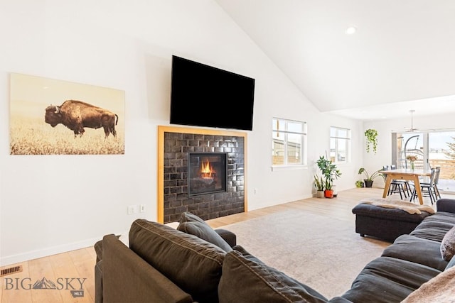 1991 Ryun Sun Way, Bozeman, MT 59718 - living room featuring wood finished floors, high vaulted ceiling, recessed lighting, and a glass covered fireplace