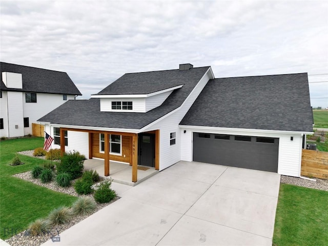 1991 Ryun Sun Way, Bozeman, MT 59718 - modern inspired farmhouse with concrete driveway, a front lawn, an attached garage, and a shingled roof