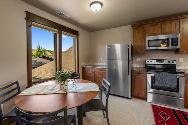 2497 Northview, Bozeman, MT 59715 - kitchen with stainless steel appliances, brown cabinetry, and light colored carpet