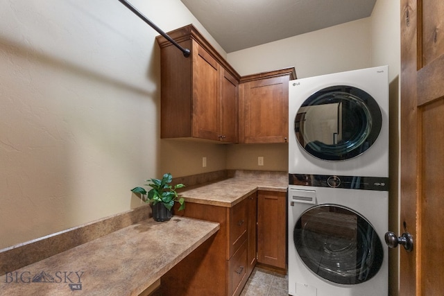 2497 Northview, Bozeman, MT 59715 - washroom with stacked washer and clothes dryer, cabinet space, and light tile patterned floors