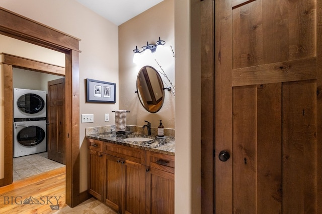 2497 Northview, Bozeman, MT 59715 - bathroom featuring stacked washer and clothes dryer, vanity, and wood finished floors